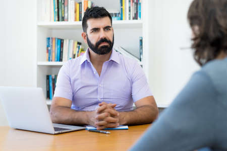 Serious businessman with beard in discussion at job interview at office of companyの写真素材