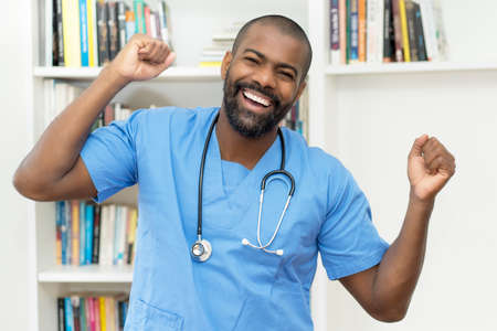 Cheering african american mature nurse or doctor at office of hospitalの写真素材
