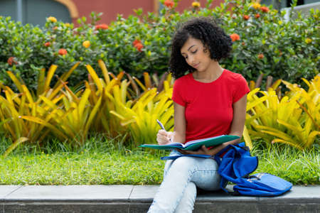 Young spanish female student learning at campus of universityの写真素材