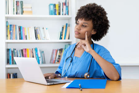 Smart afro american nurse or medical student at computer at hospitalの写真素材