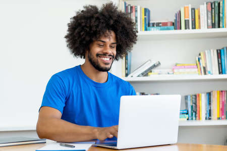 Laughing african american software engineer at computer at office of start up companyの写真素材