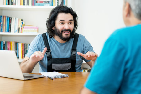Handsome handyman talking about contract and order with customer at workplaceの写真素材