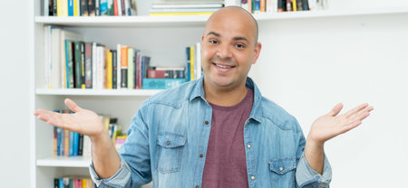 Friendly laughing bald mature adult man indoors at homeの写真素材
