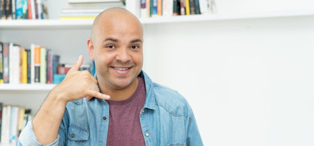 Call a nice guy with bald and casual clothes indoors at homeの写真素材
