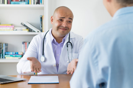 Doctor talking with patient about cancer surgery at office of clinicの写真素材