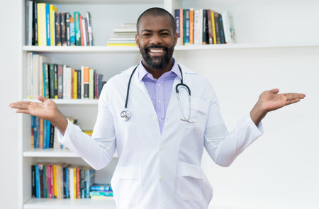 Friendly mature adult african american doctor with beard and stethoscope at office of hospitalの写真素材