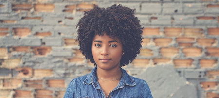 Portrait of african american young adult woman outdoor in cityの写真素材