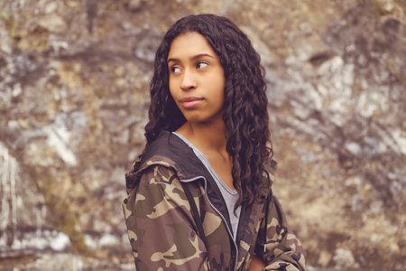 Pretty mexican female young adult in camouflage clothing outdoor in urban city styleの写真素材