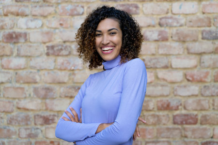 Portrait of mexican woman with curly hair in urban styleの写真素材