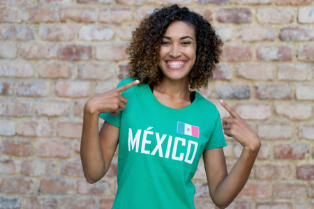 Pretty mexican female football fan with green soccer jersey