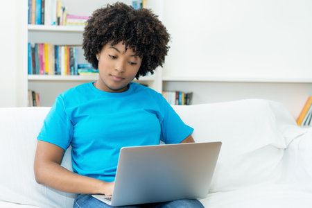 African american female student learning at computer indoors at homeの写真素材
