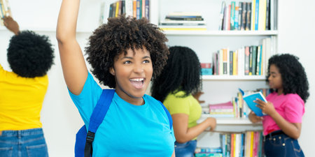 Successful black female student with group of african american college students indoors at libraryの写真素材