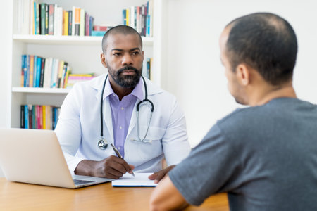Serious mature adult african american male doctor listening patient at office of hospitalの写真素材