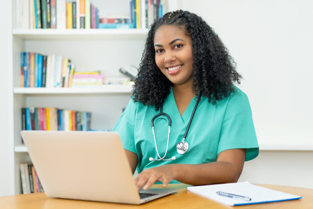 Laughing latin american medical student or female nurse working at computerの写真素材