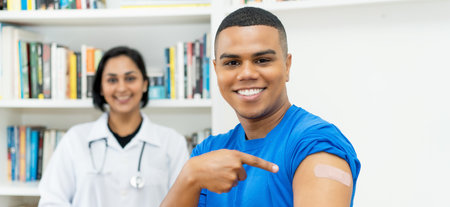 Laughing mexican young adult man after vaccination at hospitalの写真素材