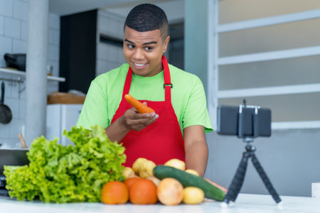 Young latin american food blogger streaming video clip of cooking healthy food with tomatoes and potatoes and saladの写真素材