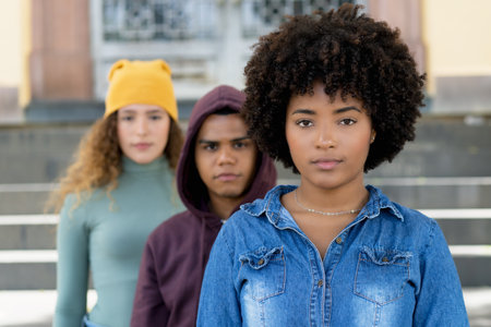 Serious african american woman with caucasian and hispanic friends in a row outdoor in cityの写真素材