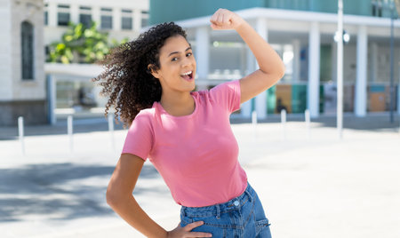 Successful cheering hispanic young adult woman outdoor in cityの写真素材