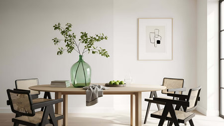 Round wooden table showing round wooden dining table with green vase leafy plant and wicker chairs....