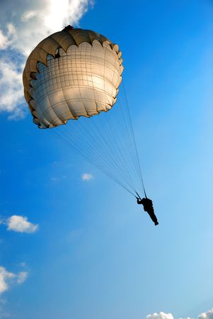 single parachute jumper against blue sky backgroundの写真素材