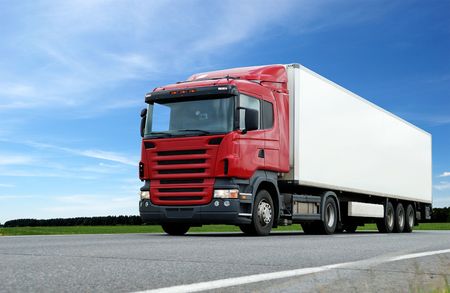 lower camera view of red lorry with white trailer on the highway over blue skyの写真素材