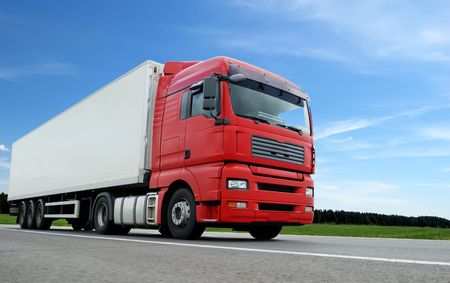 lower camera view of red lorry with white trailer on the highway over blue skyの写真素材