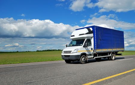 yellow delivery truck outdoor on the highway over blue cloudy sky. の写真素材