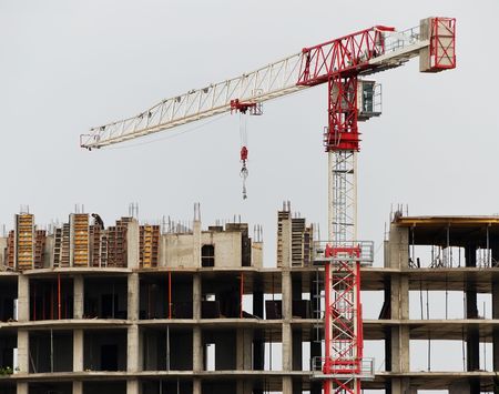 Single tower column crane building business centre at construction siteの写真素材