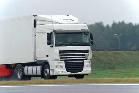 White lorry with white trailer at wet road during the rain. Find more vans and trucks in my portfolioの写真素材