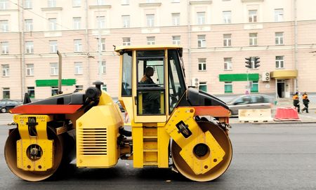 Heavy yellow roller compactor asphalting the town roadの写真素材