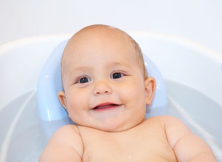 smiling Baby lying in the bath with waterの写真素材