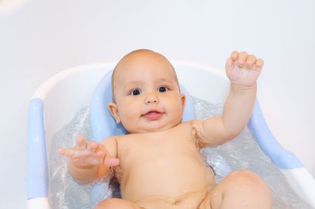 Little Baby during bathing raising his handsの写真素材