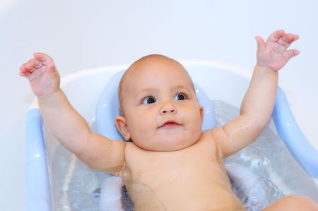 Little Baby during bathing raising his handsの写真素材