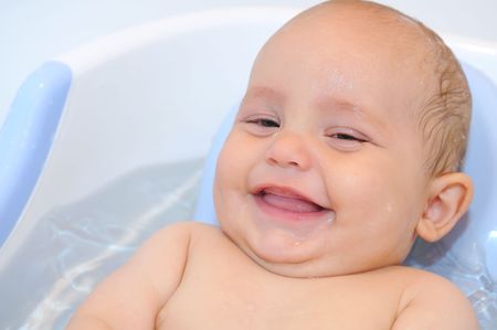 close-up portrait of smiling Baby lying in the bath with waterの写真素材