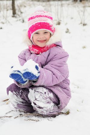 little happy girl playing at snowy winter outdoorの写真素材