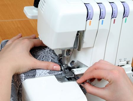 two woman hands sewing on the stichting machine