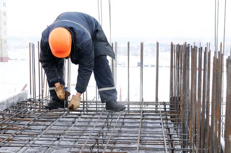 worker in workwear making reinforcement metal framework for concrete pouringの写真素材