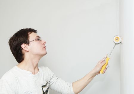Painter worker hand at decoration work painting a wall with rollerの写真素材
