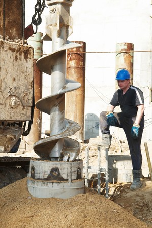 worker controlling piling process tube in metal form for continuous concrete casting