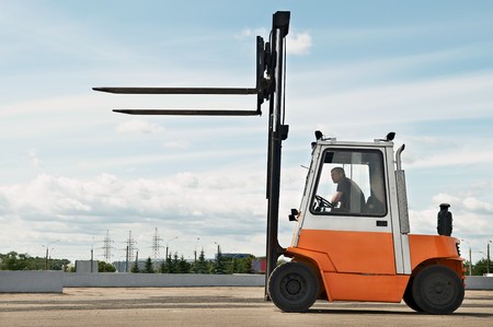 Forklift loader for warehouse works outdoors with risen forksの写真素材