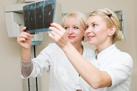 two dentist doctors looking at X-ray tooth imageの写真素材