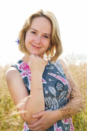 portrait of smiling cheerful woman outdoors in summer fieldの写真素材