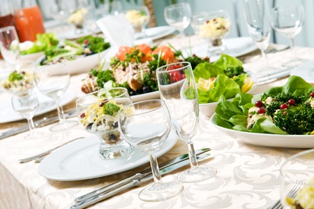 catering table set service with silverware and glass stemware at restaurant before partyの写真素材