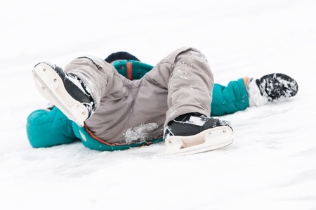physical injury of little child boy during winter sport skatingの写真素材