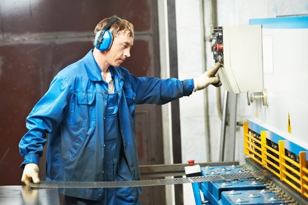 worker operating guillotine shears machine