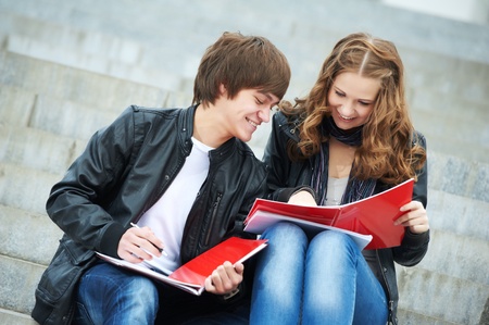 Two smiling young students studying outdoorsの写真素材