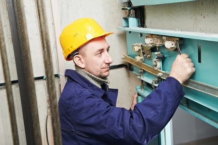 machinist with spanner adjusting lift mechanismの写真素材