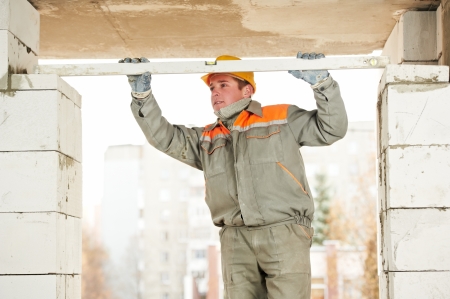 mason worker bricklayer builder with levelの写真素材