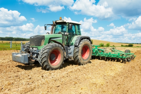Ploughing tractor at field cultivation workの写真素材