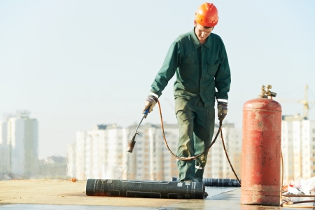 Flat roof covering repair works with roofing feltの写真素材